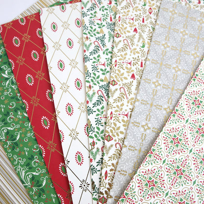 A stack of Christmas 12x12 Cardstock with red, green, and gold designs.