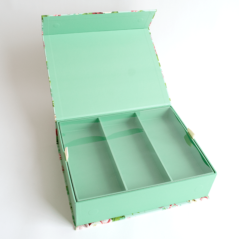 a green box with four compartments on a white surface.