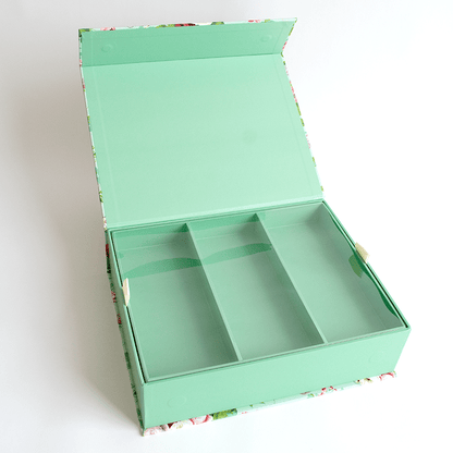 a green box with four compartments on a white surface.