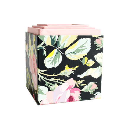 a black and pink flowered box with pink handles.