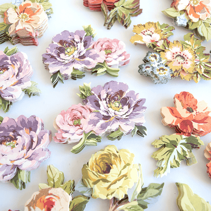 a table topped with lots of paper flowers.