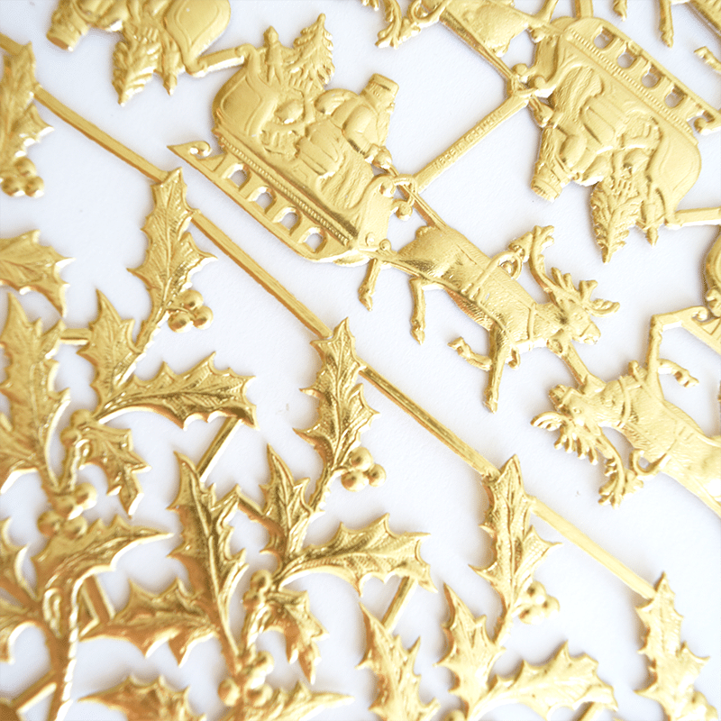 a close up of a gold plated design on a white surface.