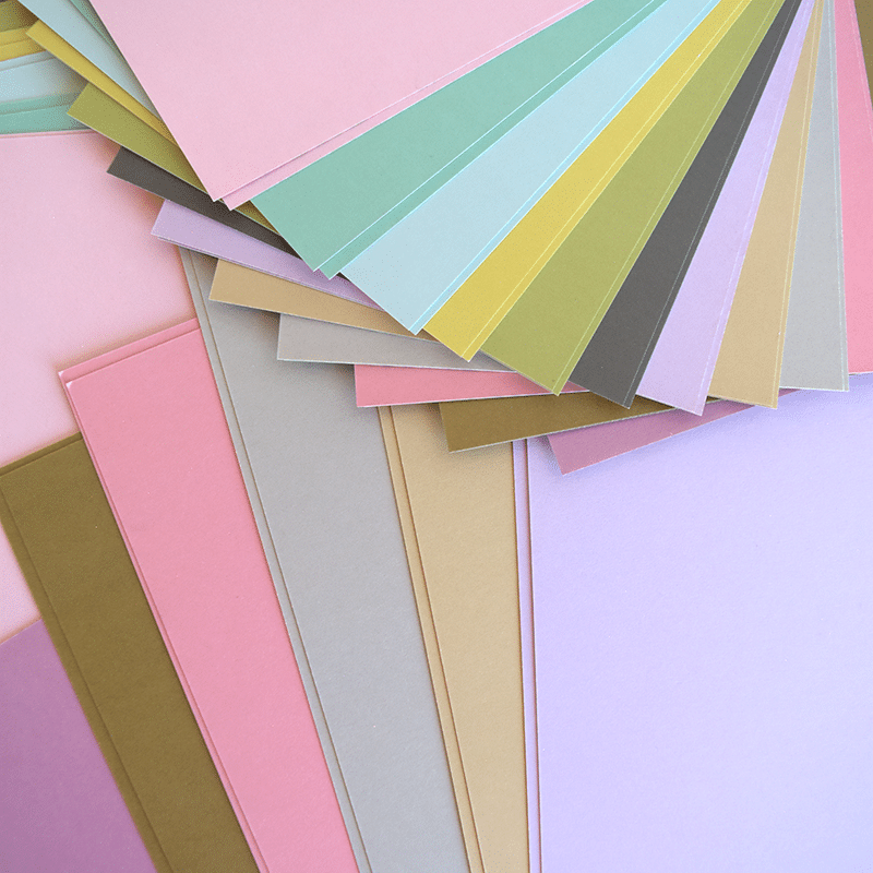 a bunch of different colors of paper on a table.