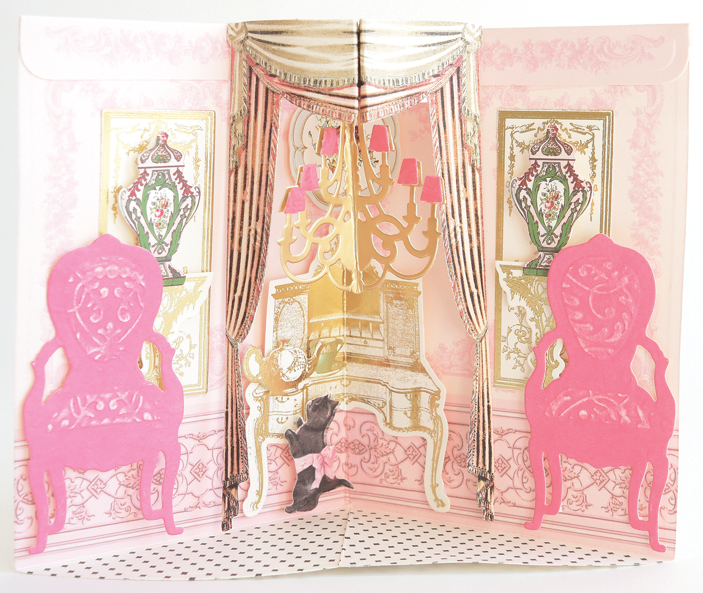 a pink and gold card with a picture of a bed and a chandelier.