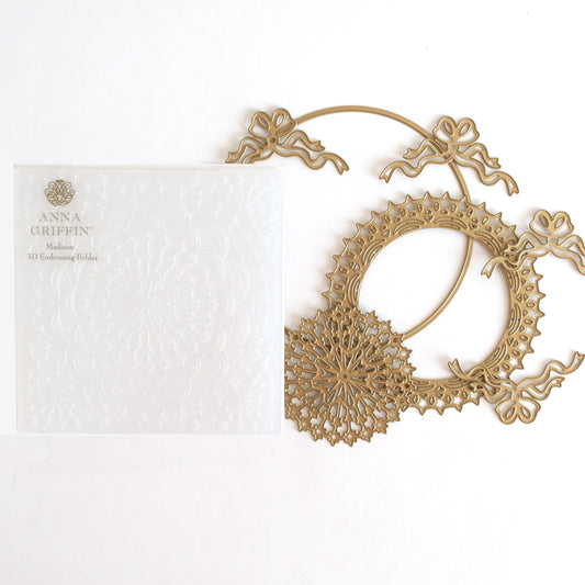 a white card with a gold filigree on it.