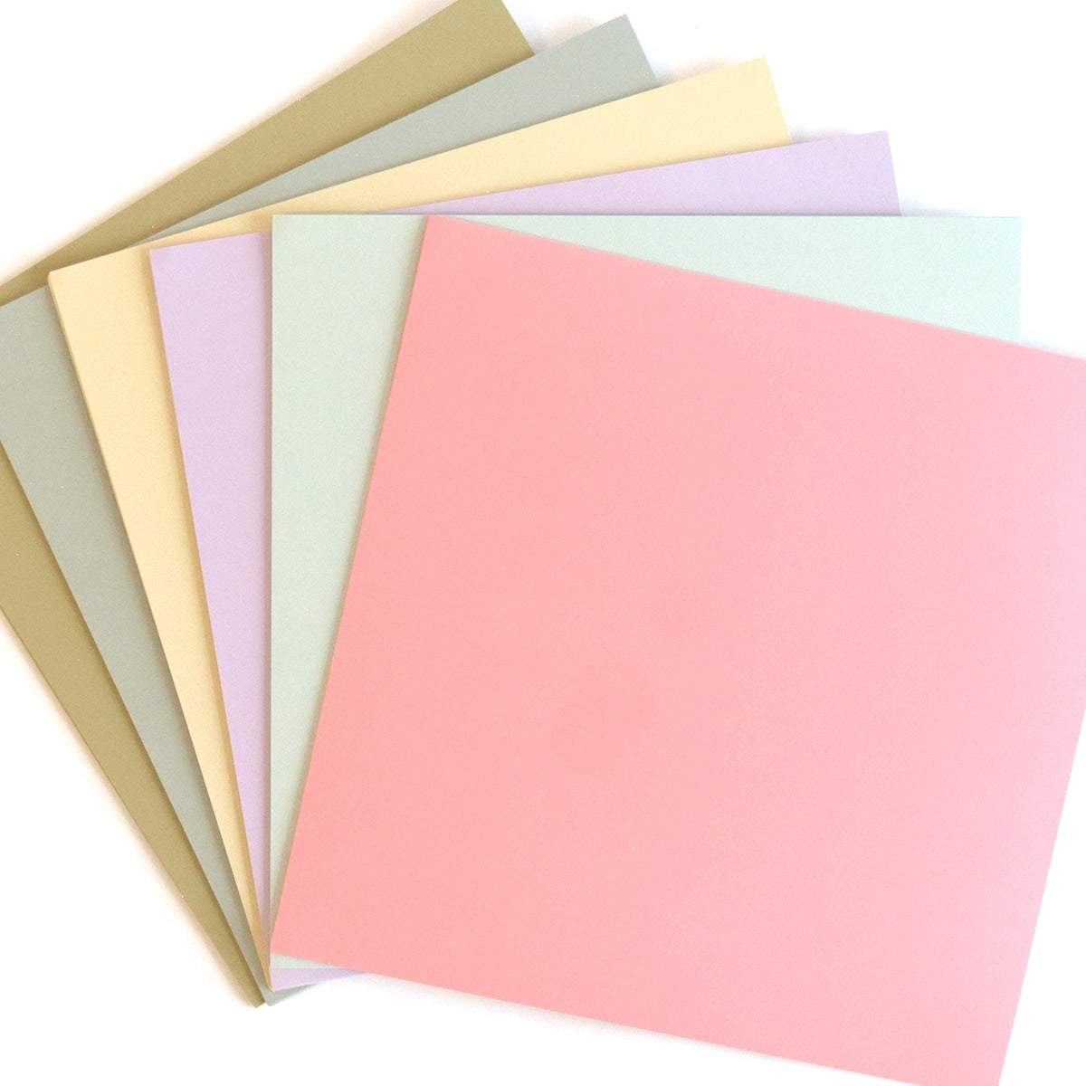 a stack of pastel colored paper on a white background.
