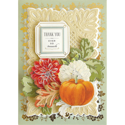 a card with a pumpkin and flowers on it.