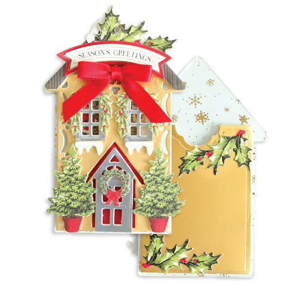 a christmas card with a house and a red bow.