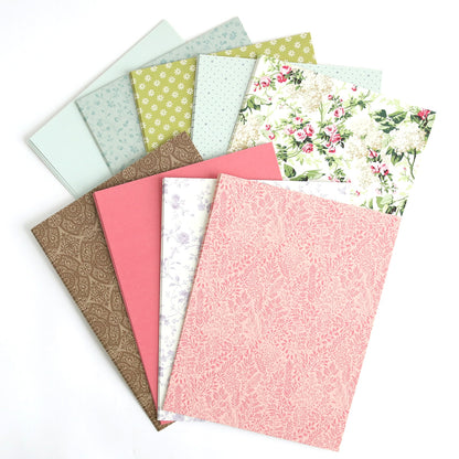 A stack of Wishing Well Double Sided Cardstock with floral designs on them.