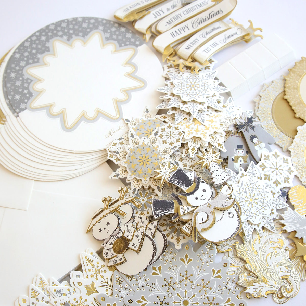 A white and gold scrapbooking kit with Simply Rocking Snowflake Card Kit and snowflakes.