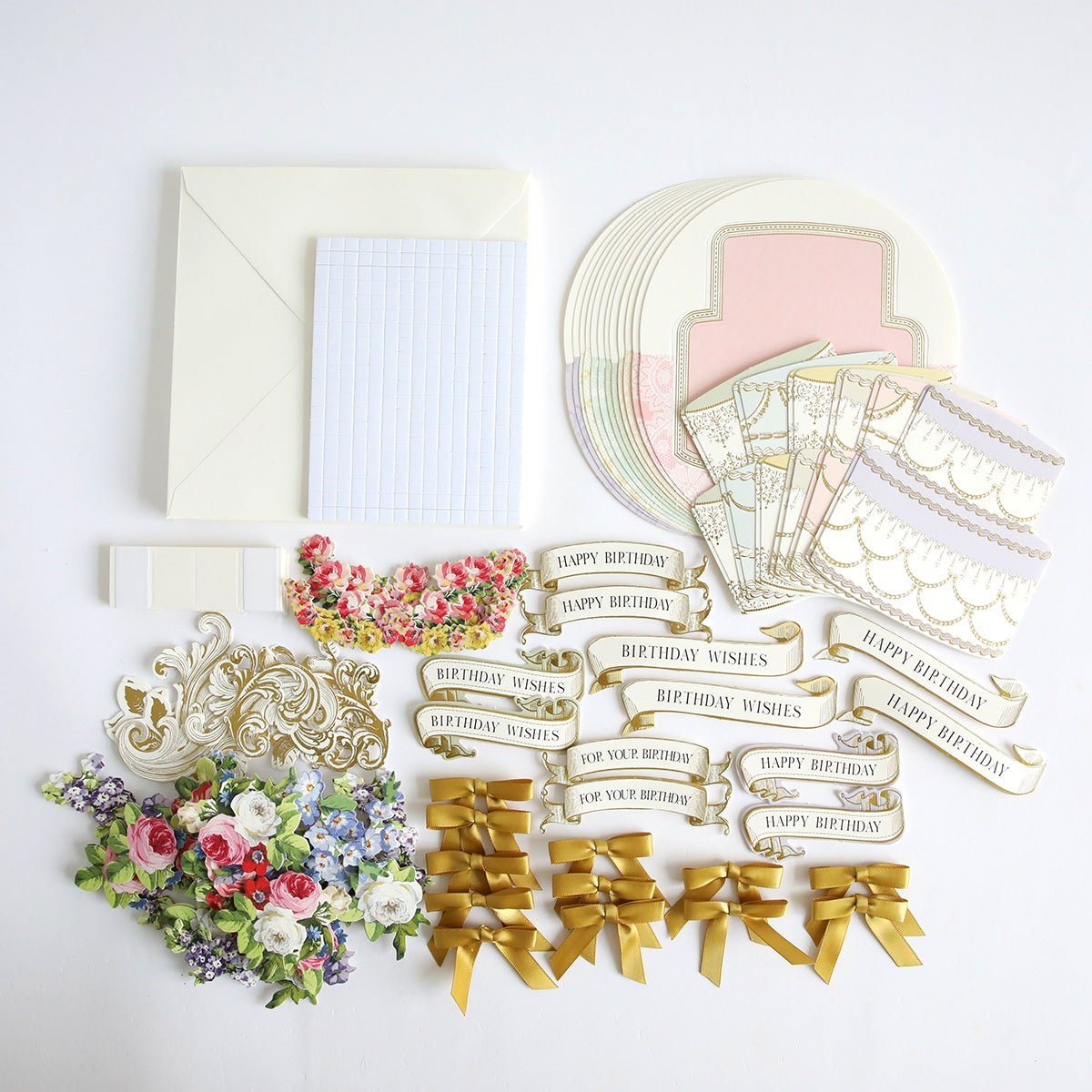 A collection of papers, ribbons, and Simply Rocking Birthday Card Kit are laid out on a white surface.