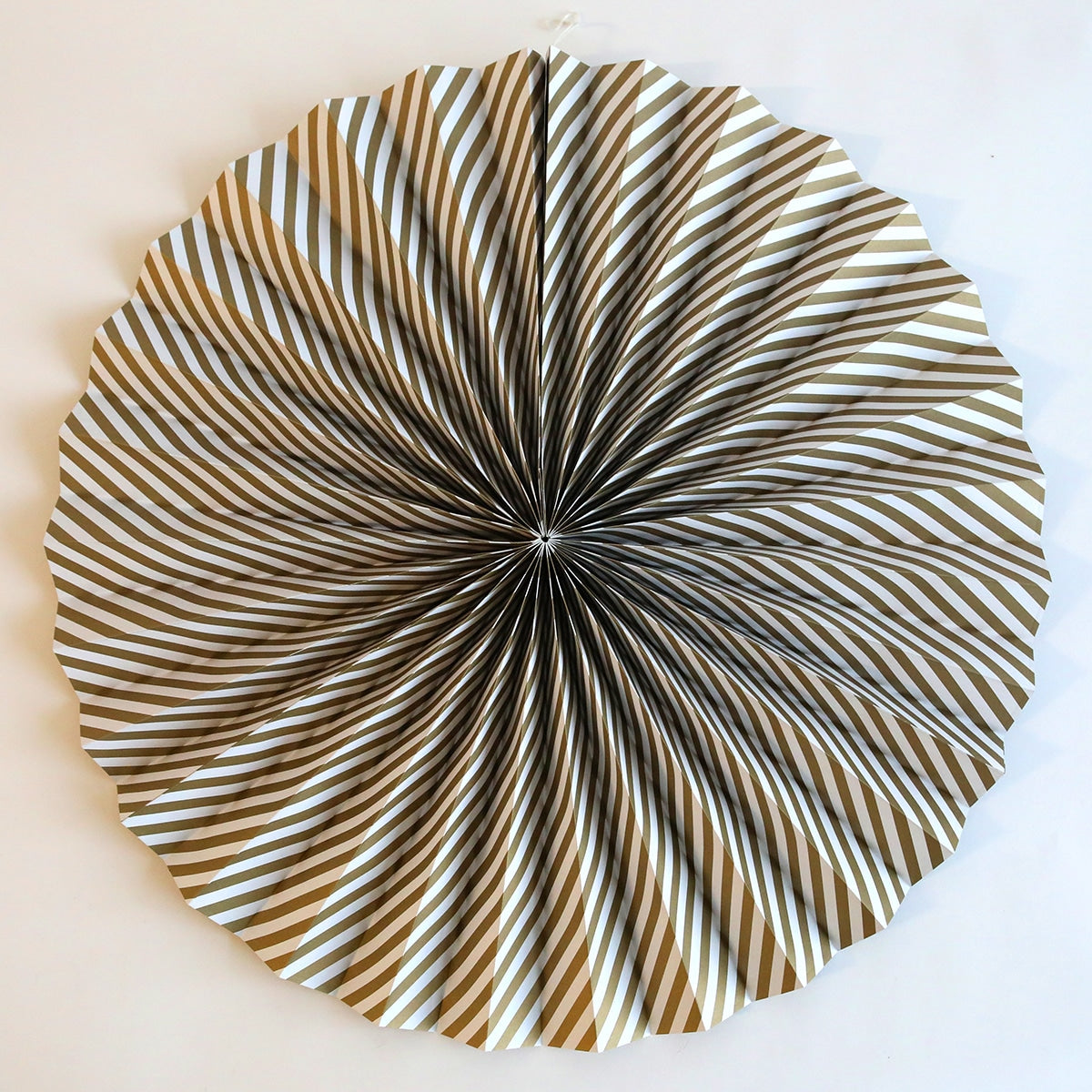 a circular metal object on a white wall.