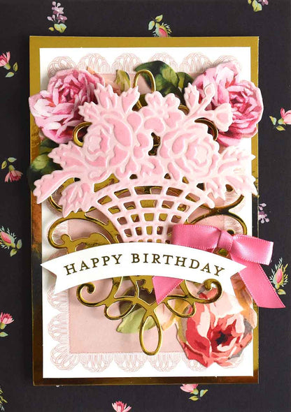 a birthday card with pink flowers and a ribbon.