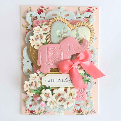a welcome card with a pink elephant and flowers.