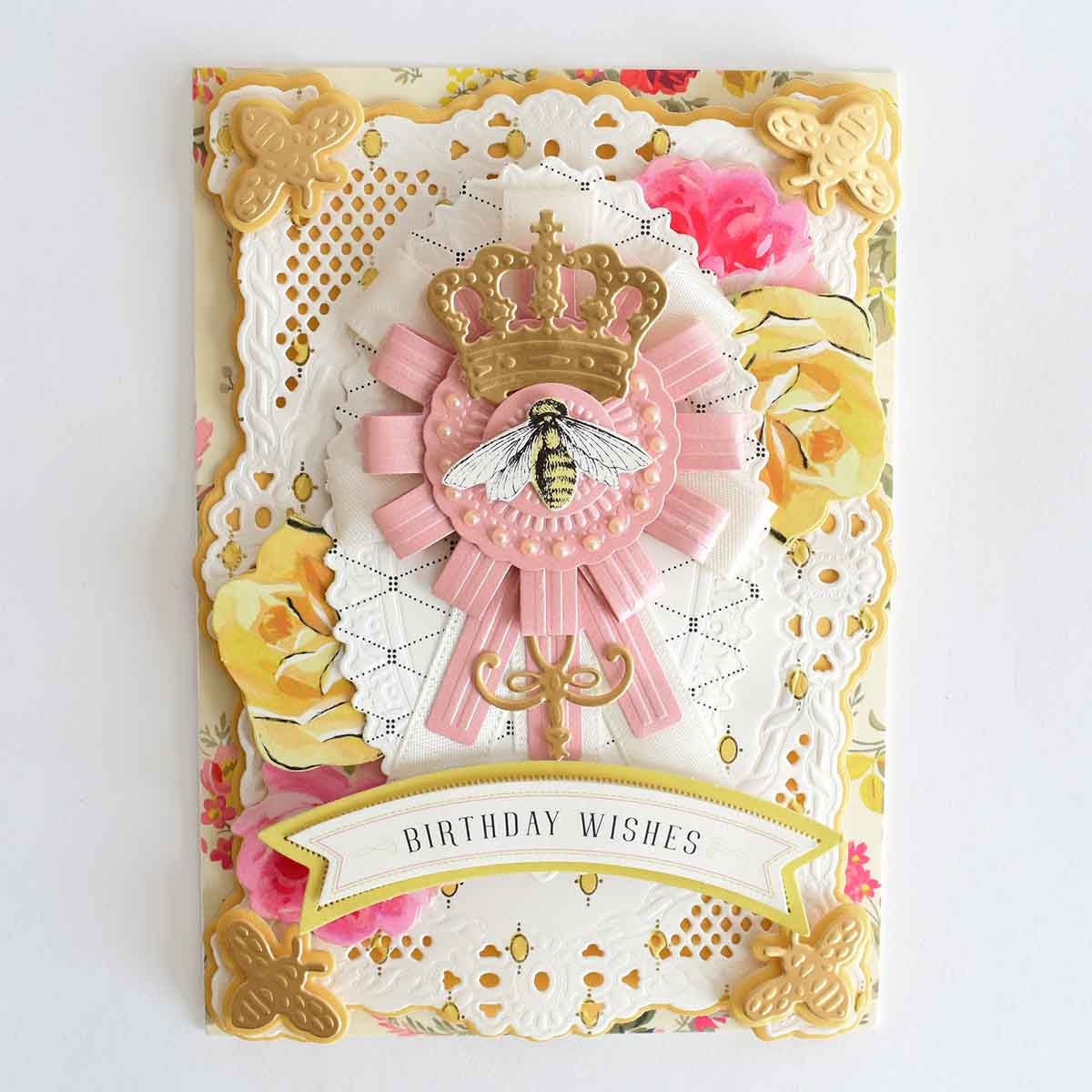a birthday card with a pink ribbon and a crown.