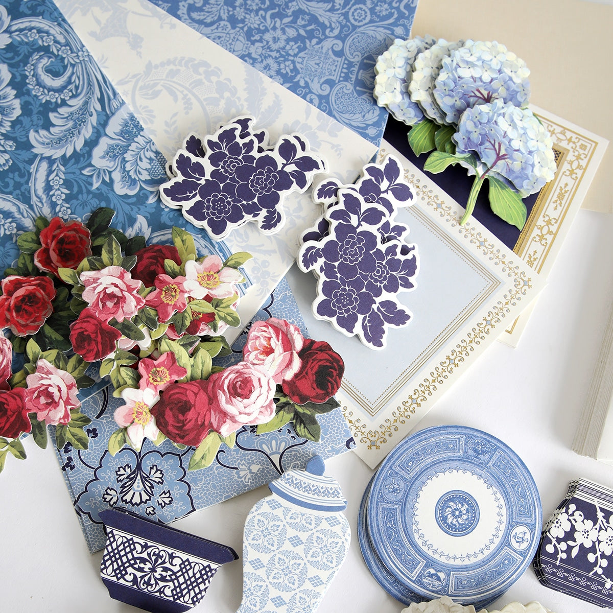 a table topped with blue and white vases filled with flowers.
