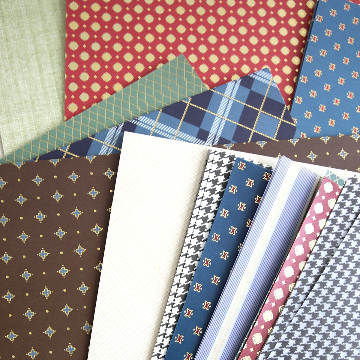 A pile of Carte Homme Cardstock and Vellum sheets in different colors on a table.