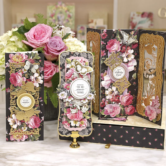 a table topped with boxes and vases filled with flowers.