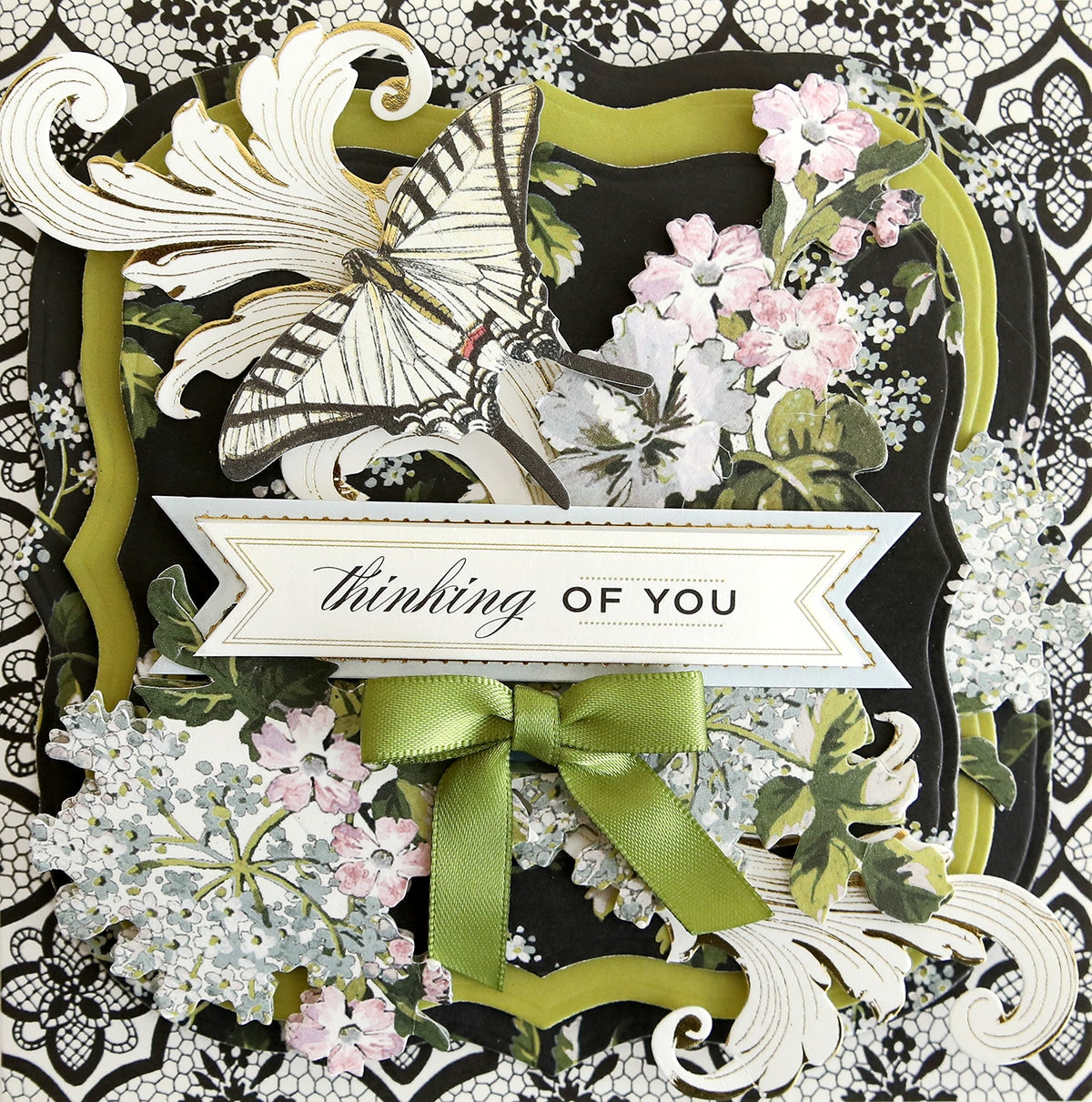 a close up of a card with flowers and a ribbon.