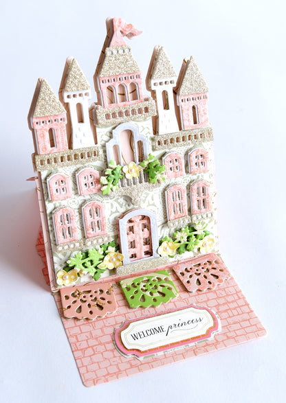 a pink and white card with a castle on it.