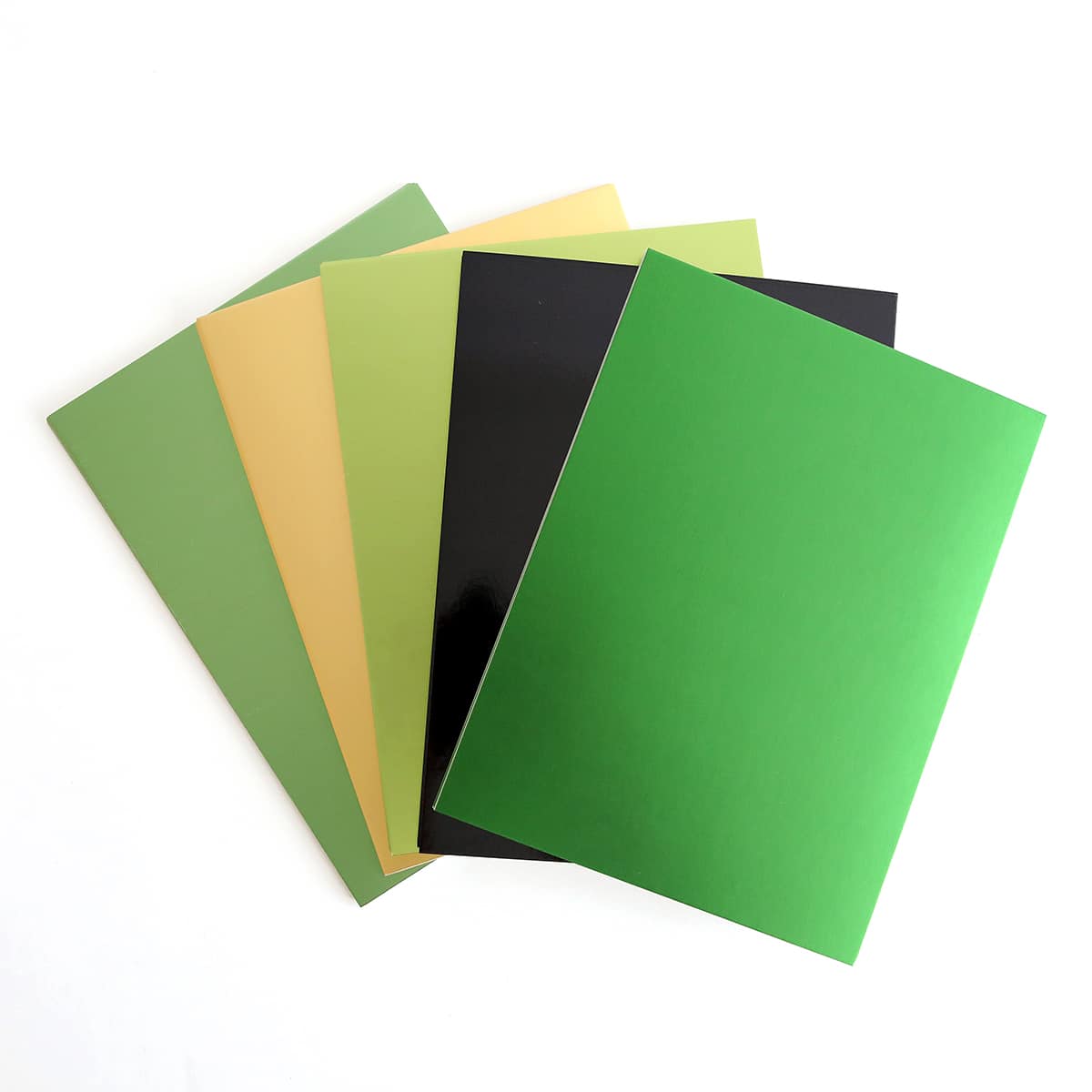 a stack of different colors of paper on a white surface.