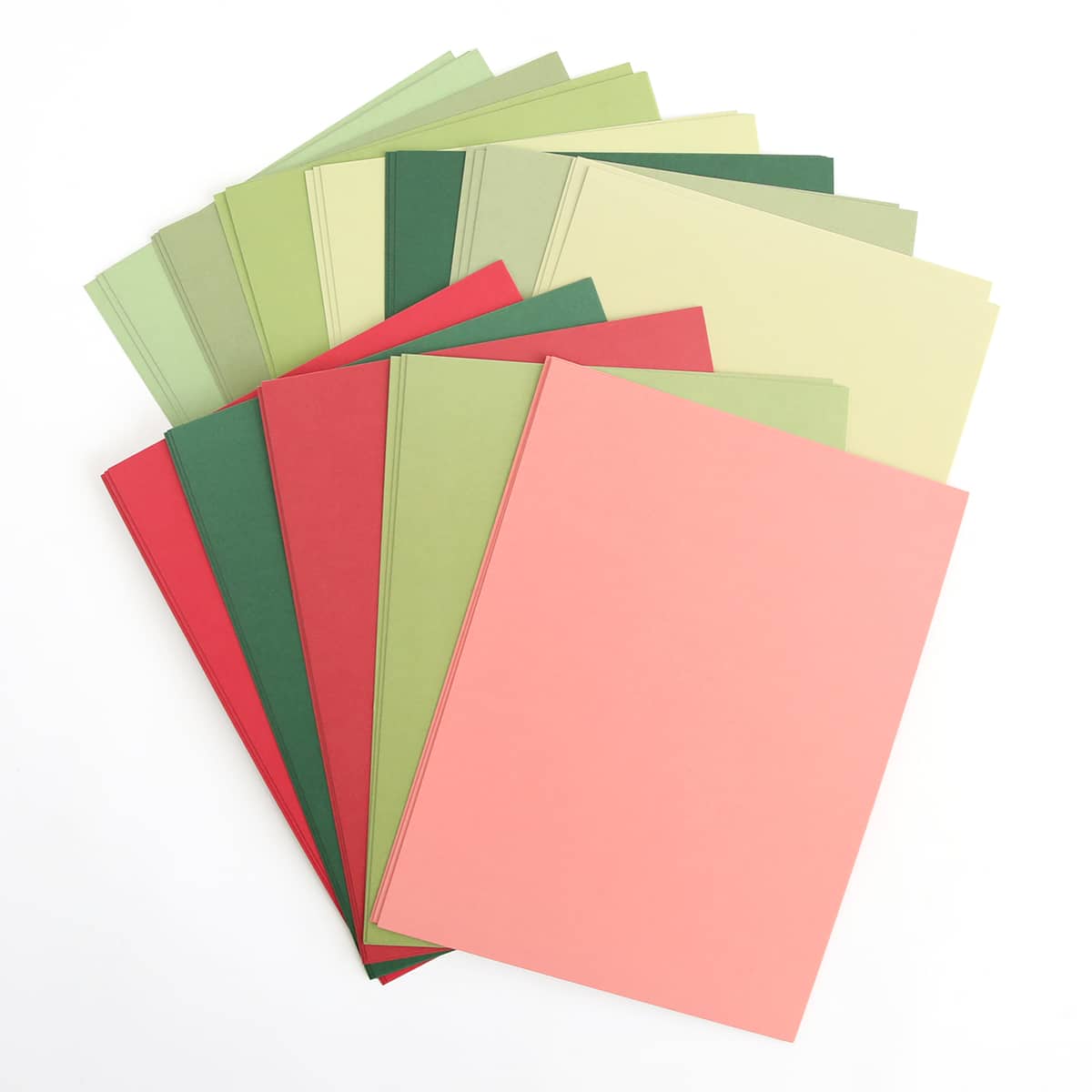 a stack of different colored papers on a white surface.