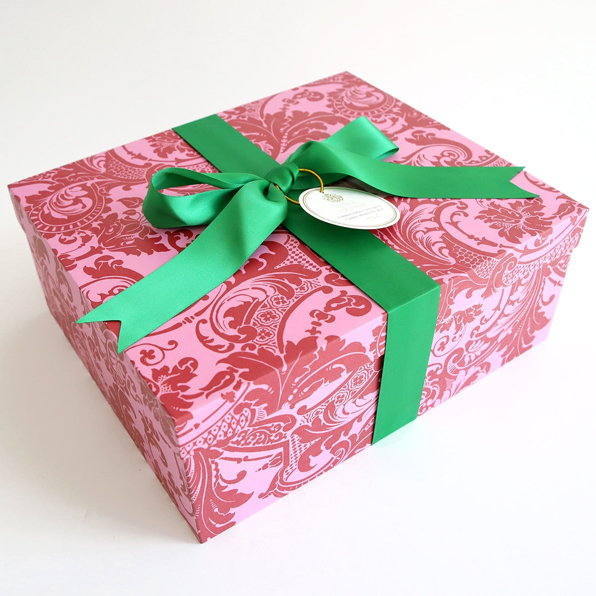 A pink and green Christmas Wishes Card Making Kit with a green ribbon.