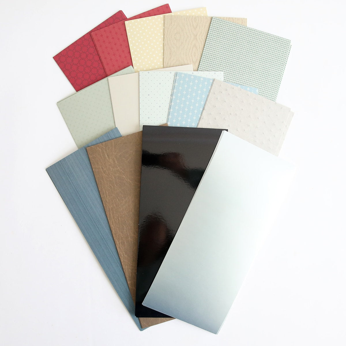 A pile of Classic Car Cardstock in different colors on a white surface.