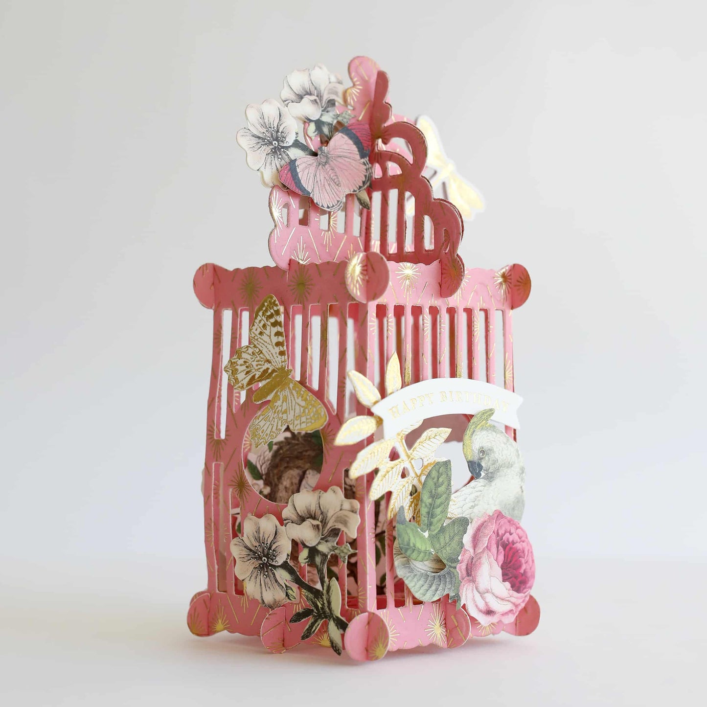a pink birdcage with flowers and butterflies on it.