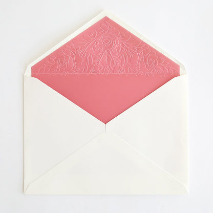 a white envelope with a pink envelope inside.
