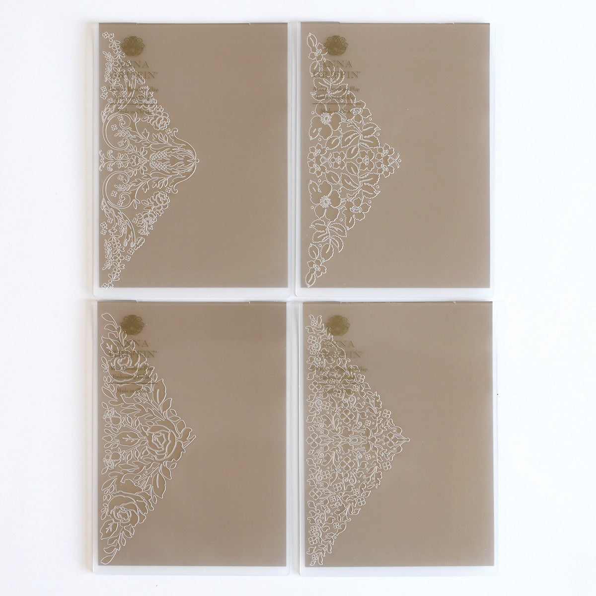 four pieces of glass with white designs on them.