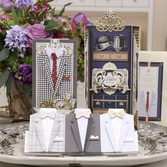 a table topped with cards and a vase filled with flowers.