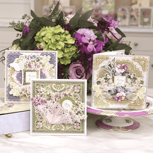 a table topped with cards and a vase filled with flowers.