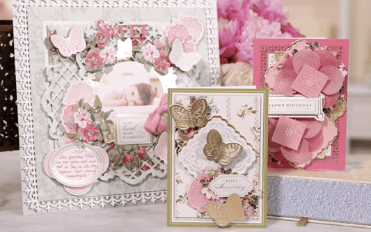 a table topped with cards and a vase filled with flowers.