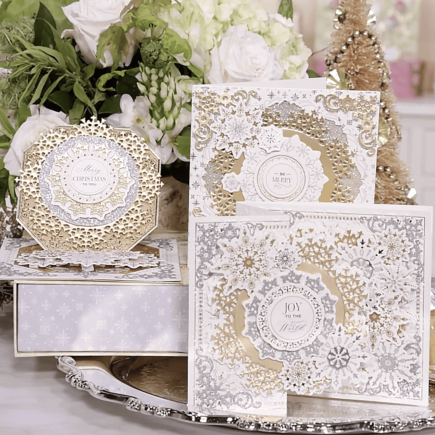 a table topped with lots of white and gold cards.