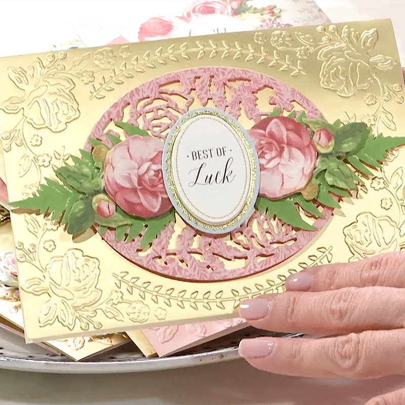 a woman's hand holding a piece of paper with flowers on it.