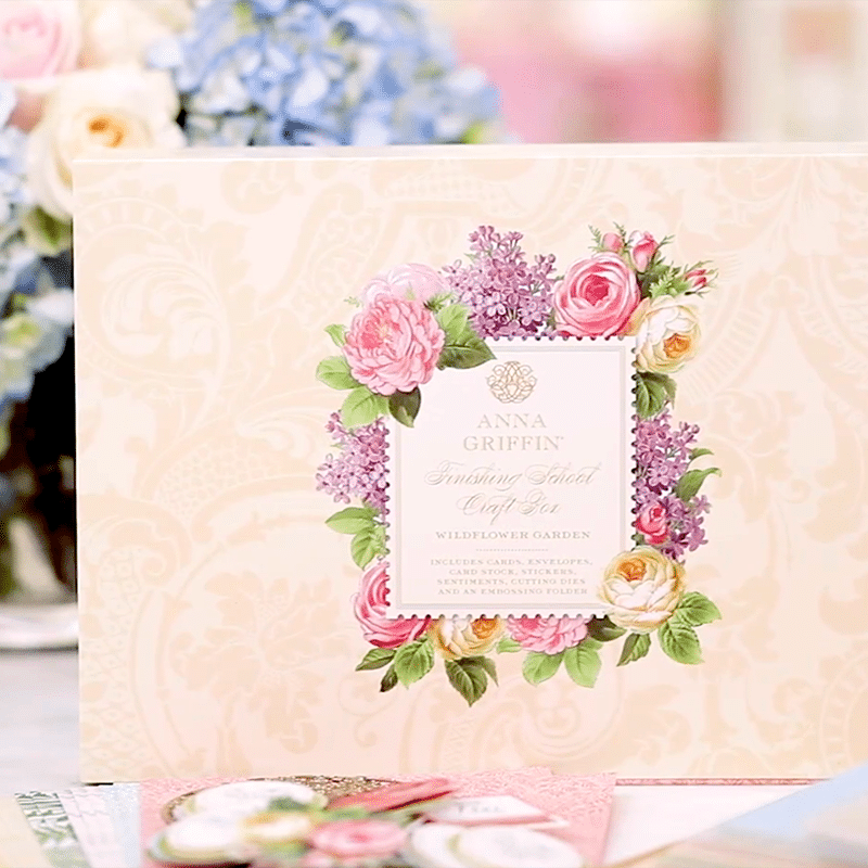a wedding card with flowers on it sitting on a table.