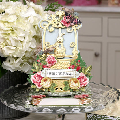 A Wishing Well Easel Finishing School Class with roses and flowers on a table.