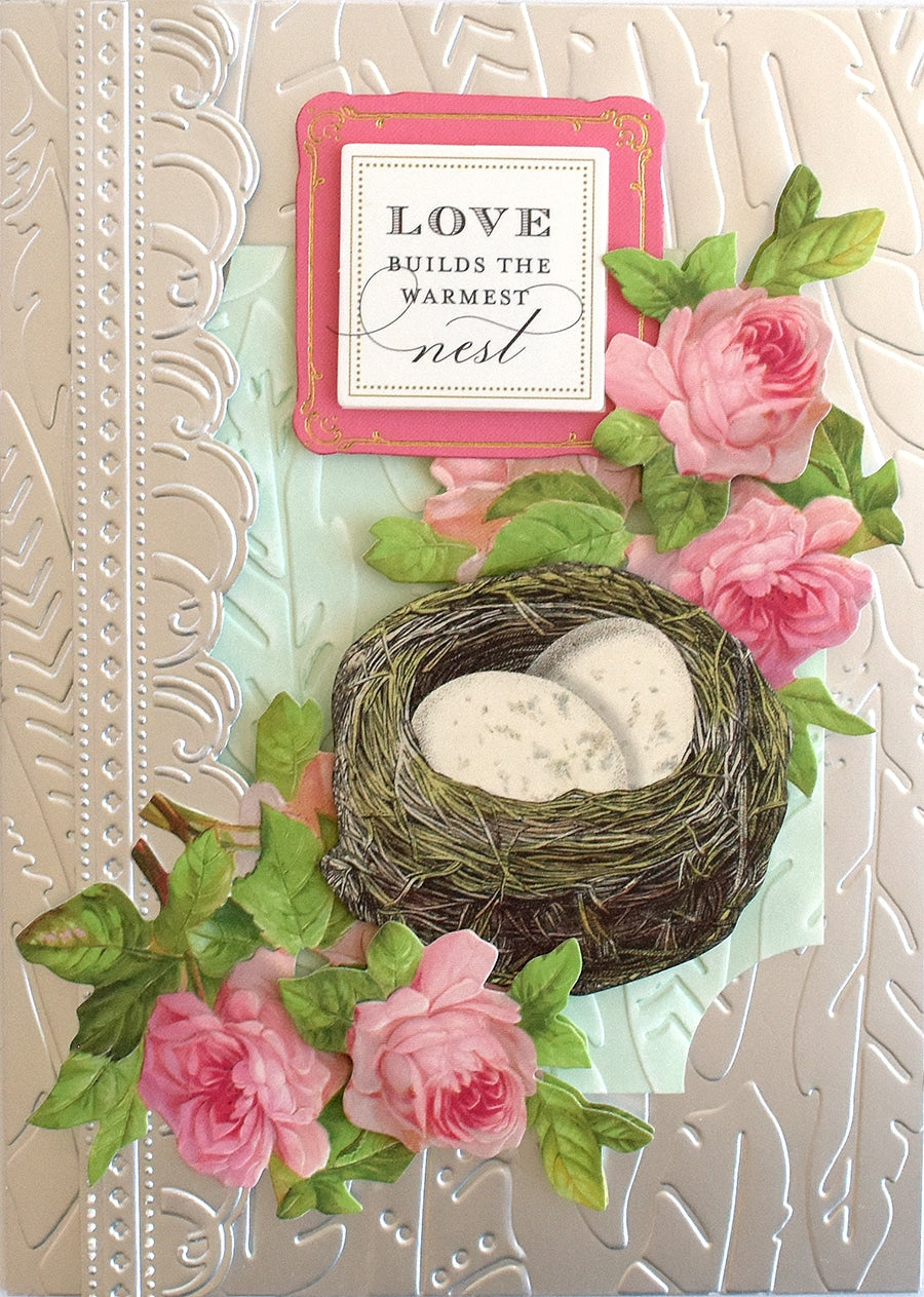 a card with a bird's nest and pink flowers.