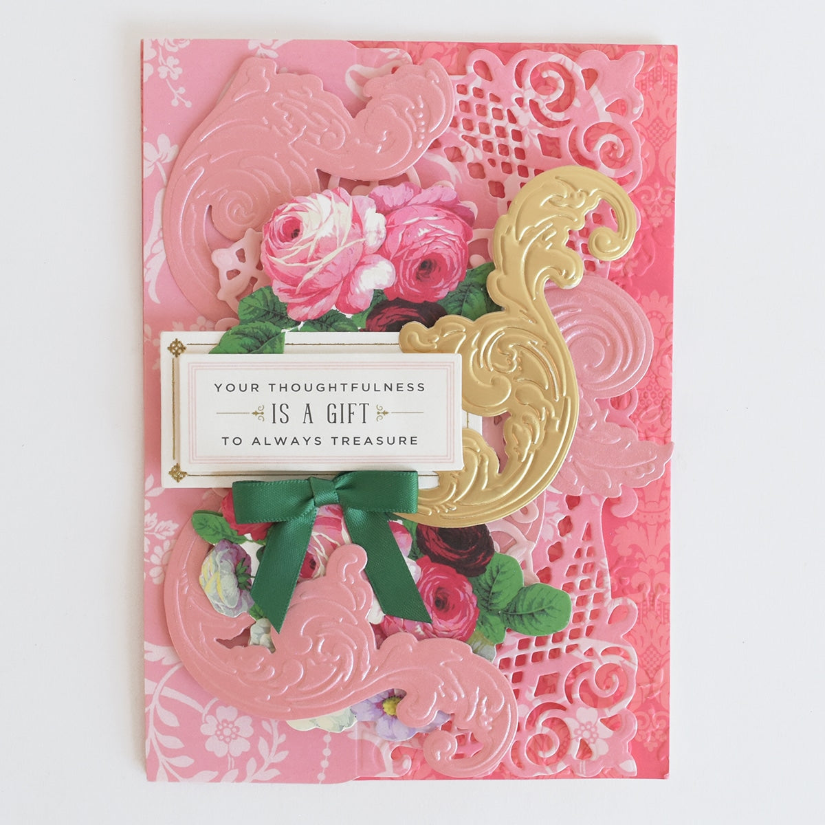 a pink and gold card with flowers on it.