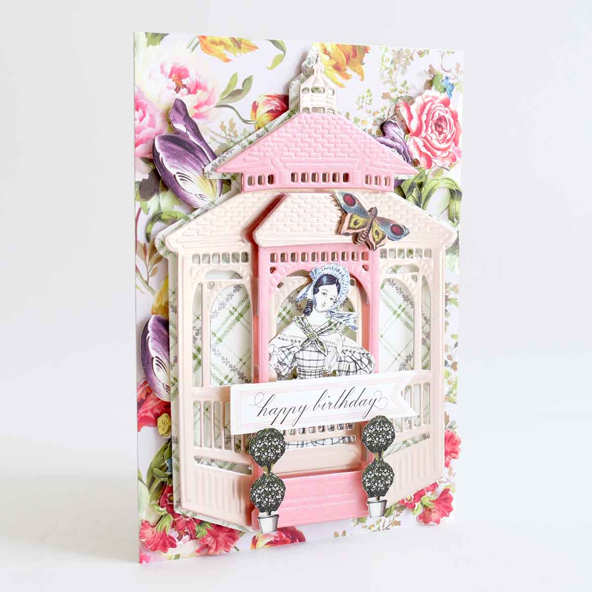 a birthday card with a pink house and flowers.
