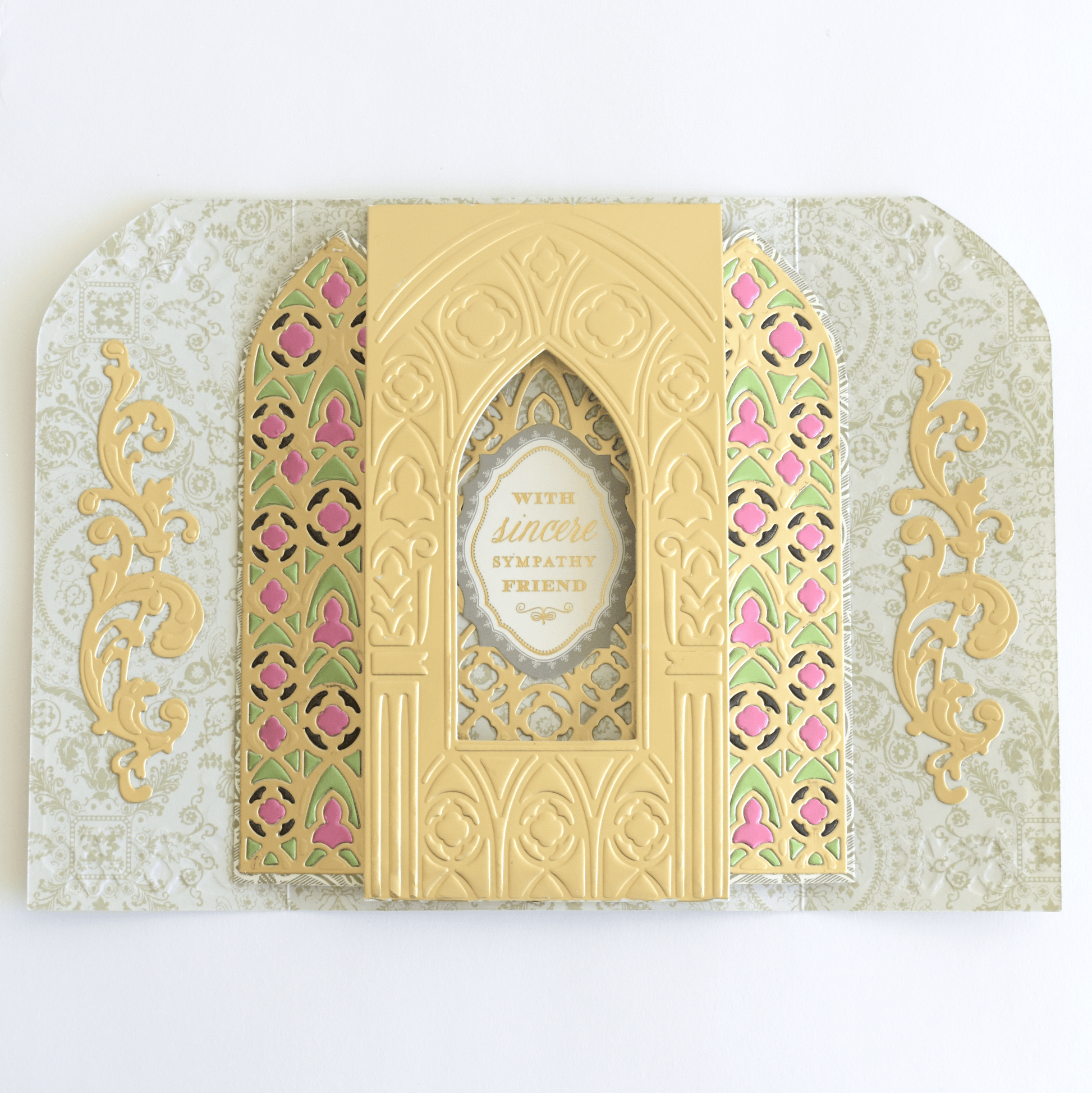 a card with a gold and pink design on it.