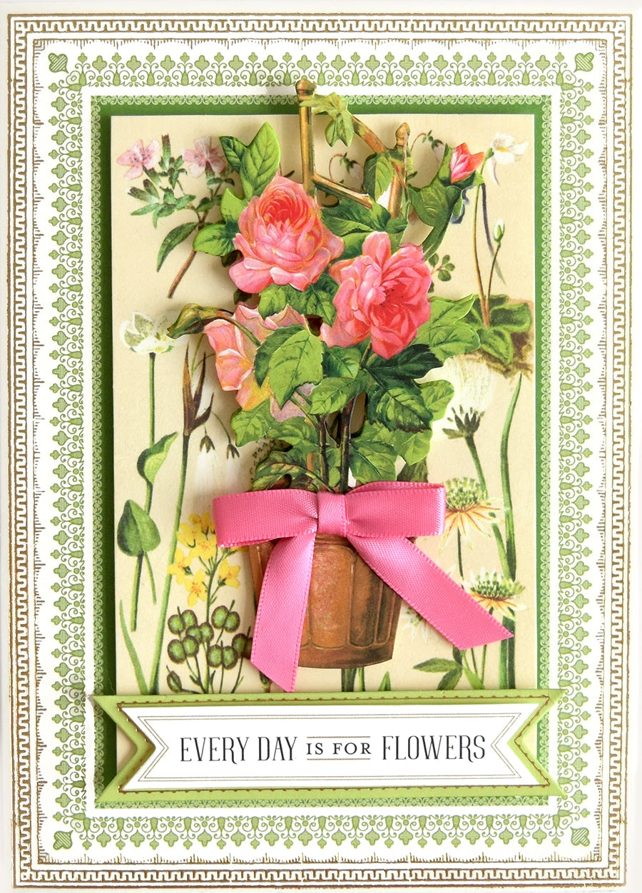 a card with flowers and a pink ribbon.