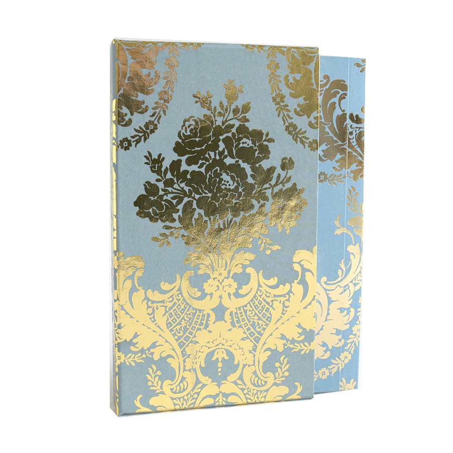 a blue and yellow book with a gold flower on it.
