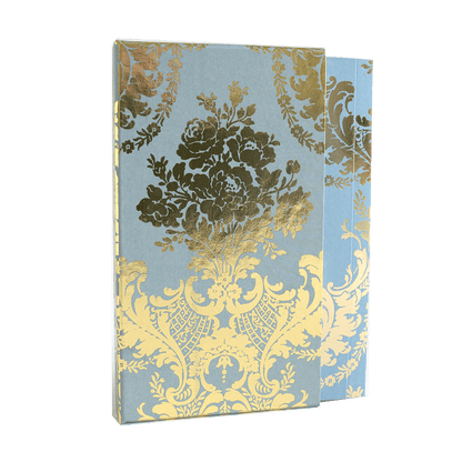 a blue and yellow book with a gold flower on it.
