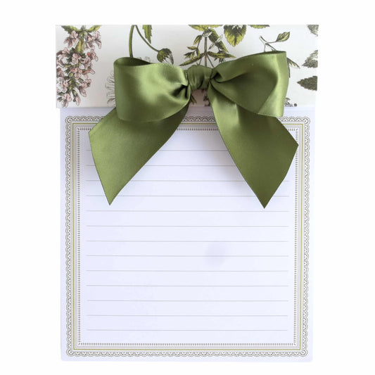 a note with a green bow on top of it.