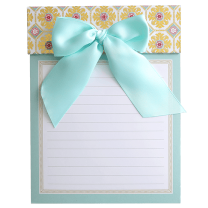 a notepad with a bow on top of it.