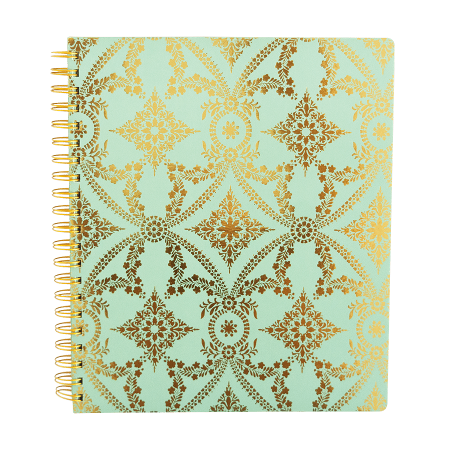 a spiral notebook with gold foil on a light green background.