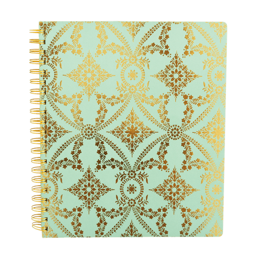 a spiral notebook with gold foil on a light green background.