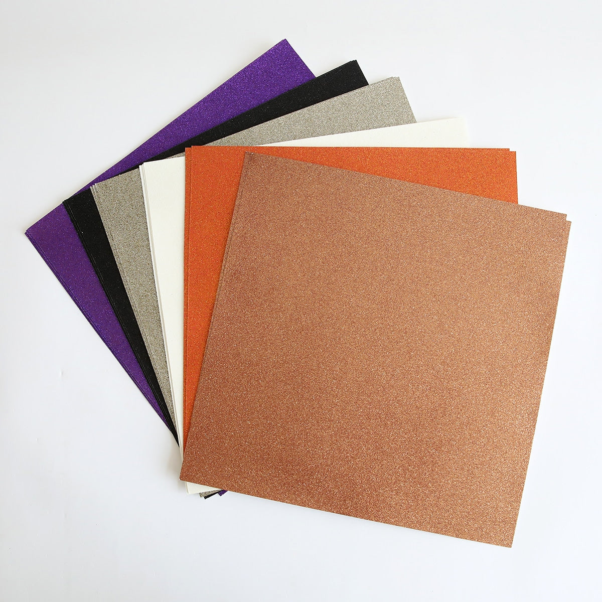 A group of Halloween 12x12 Glitter Cardstock papers on a white surface.